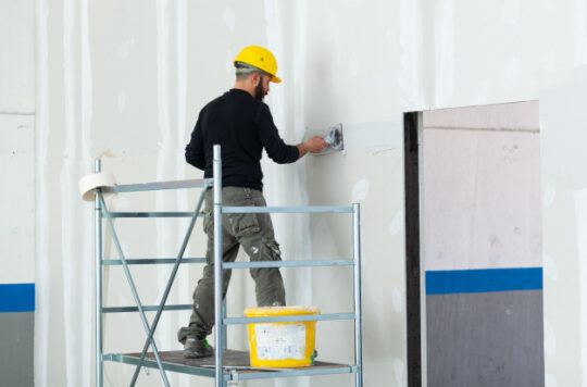 trabajador-enlucido-pared-tablero-drywall